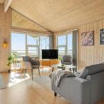 Living room with wooden walls, sofa, TV, and large windows for views.