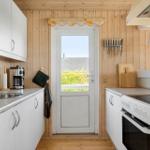 Kitchen with white cabinets, stainless steel sink, and door to balcony.