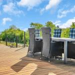Deck with table and chairs, view of water and greenery.