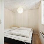Schlafzimmer mit Bett, Fenster und Deckenleuchte.