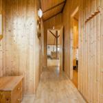 Holzverkleideter Flur mit Schrank, Spiegel und Blick in Wohn- und Schlafzimmer.