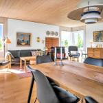 Esszimmer mit Holztisch und Stühlen. Wohnbereich mit Sofa, Kamin und Fenstern.