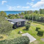 Schwarzes Haus mit Garten und Blick auf Wasser