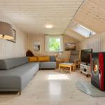 Wohnzimmer mit Sofa, Kamin und Fenster. Holzwände und -decke.
