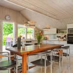 Küche mit Essbereich, Holztisch, Stühlen und Blick auf den Garten.