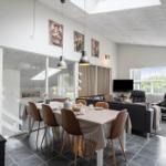 Essbereich mit Tisch und Stühlen, Wohnzimmer mit Sofa und Kaminofen.