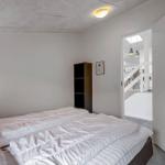 Schlafzimmer mit Bett, Kleiderschrank und Tür zum Flur.