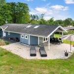 Ein Haus mit Terrasse, Liegestühlen und Grillplatz im Garten.