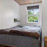 Bedroom with bed, window, and nightstand.
