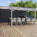 Deck with table, chairs, grill, and pergola under blue sky.