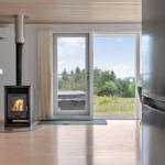 Room with fireplace, refrigerator, and view of garden.