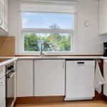 Kitchen with window, sink, dishwasher, and cooking appliances.