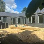 Neubau mit grauen Wänden und großen Fenstern im Freien