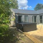 Moderne Hütte mit Außendusche und Holzterrasse im Garten