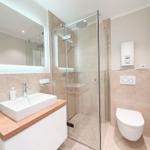 Badezimmer mit Dusche, Waschbecken und Toilette.
