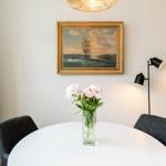 Runder Tisch mit Blumen, Wandbild und Stehlampe