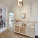 Eingangsbereich mit Sideboard, Wandbild und Licht. Durchgang in die Küche.