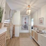 Hausgang mit Treppe, Wandbild Leuchtturm und Schrank mit Korbfronten.