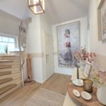 Eingangsbereich mit Treppe, Wandbild und Dekorationsgegenständen.