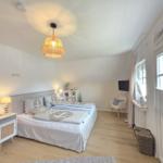Schlafzimmer mit Bett, Nachttisch, Lampe und Fenster mit Jalousie.