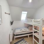 Kinderzimmer mit Doppelstockbett, Wandbild und Dachfenster.