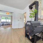 Kaminofen mit Steinwand, Wohnzimmer mit Sofa und Holzboden