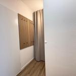 Flur mit Holzparkett, weißen Wänden und Holzgarderobe mit Haken.