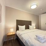 Schlafzimmer mit Bett, Nachttisch und Kleiderschrank.