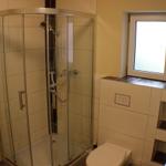 Badezimmer mit Duschkabine, Toilette und Fenster