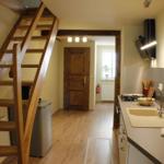 Küche mit Spüle und Holztreppe zur oberen Etage.