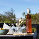Auf der Terrasse steht eine Flasche Rosé und vier Weingläser mit einer Schale Snacks.