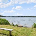 Holzbank am Ufer eines Sees mit Blick auf die gegenüberliegende Uferseite.