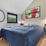 Schlafzimmer mit Bett, Fenster und Wandbild