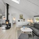 Wohnraum mit Kamin, Sofa und Fenster zur Außenansicht.