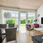 Wohn- und Essbereich mit Tisch, Stühlen, Sofa und TV. Durchgang zur Terrasse mit Garten.