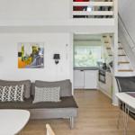Wohnbereich mit Sofa, Essbereich und Küche unter Dachschräge.