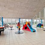 Innenhof mit Spielplatz, Billardtisch und bunten Kinderspielen.