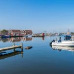 Hafen mit Booten und roten Häusern am Wasser
