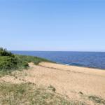 Strand mit Sand und Gras am Wasser