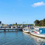 Hafen mit Booten und Steg unter blauem Himmel