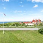 Rotes Haus am Wasser mit Flagge und Grünflächen im Vordergrund.