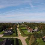 Ausblick auf Ferienhäuser mit Grünflächen und Blick auf Wasser.