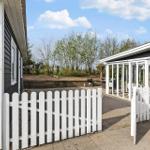 Terrasse mit Grill, Tisch und Sitzgelegenheiten neben einem Haus mit Glasveranda.