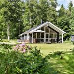 Ein Haus mit großem Glasbereich und Terrasse im Grünen.