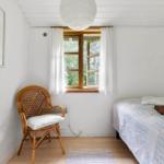 Ein Schlafzimmer mit einem Bett, einem Stuhl und einem Fenster.