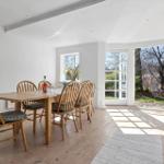 Esszimmer mit Holztisch, Stühlen und Blick auf Garten.