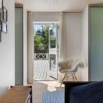 Schlafzimmer mit Blick auf Terrasse, Stuhl mit Fell, Wand mit Bildern.