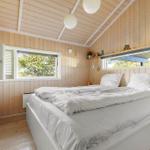 Schlafzimmer mit Holzwand, Bett und Fenstern.
