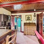 Haus mit Essbereich, Schreibtisch und Schlafzimmer. Holzdecke und antike Möbel.