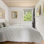 Schlafzimmer mit Bett, Fenster und Wanddekoration.